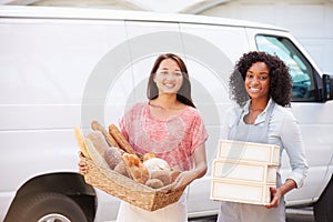 Female Bakers With Bread And Cakes Standing In Front Of Van