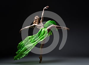 Female ballet dancer in green skirt in wind movement photo