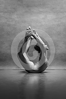 The female ballet dancer posing over gray background