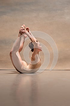The female ballet dancer posing over gray background