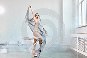 Female ballet dancer with white flowing fabric. Flow shapes and movement.