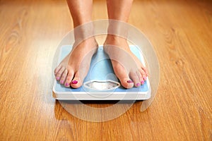 Female bare feet with weight scale