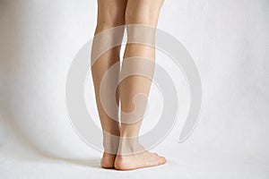 Female bare legs on a white background close up,feet on white