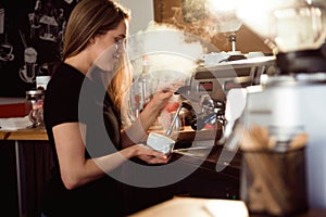 female barista making coffee in coffee shop counter. Barista female working at cafe