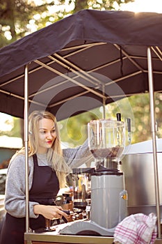 Female barrista making coffee for clients