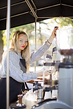 Female barrista making coffee for clients