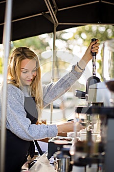 Female barrista making coffee for clients