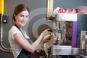 Female bartender makes coffee using coffee machine.