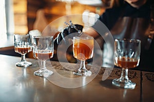 Female bartender prepares alcoholic coctail in pub