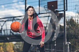 Female basketball player training outdoors on a local court