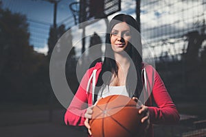 Female basketball player training outdoors on a local court