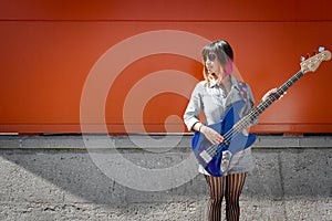 Female bass guitar player posing with blue bass