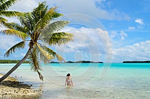 Female bathing under a hanging palm tree