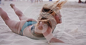 Female Beach Volleyball player diving on the sand during a game