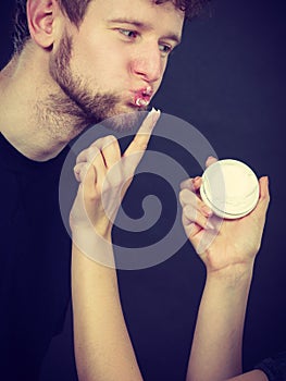 Female beautician apply cream on male mouth