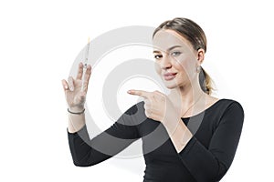 A female beautician is holding an injection syringe in her hand, pointing to it.