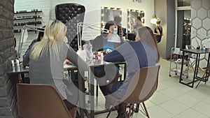 Female beauticians do different procedures and services in beauty salon.