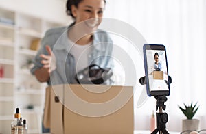 Female Beauty Blogger Unpacking Box With Cosmetics Making Video Indoors