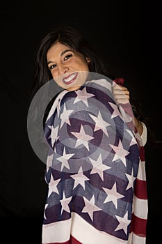 Female beauty wrapped in an American flag smiling