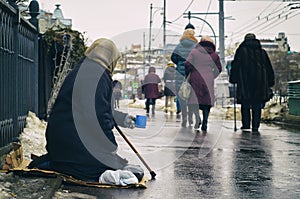 Female beggar asking for money on Moscow street in winter