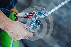 Female belayer with the rope and carabines.