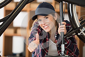 female bicycle mechanic making thumbs up gesture