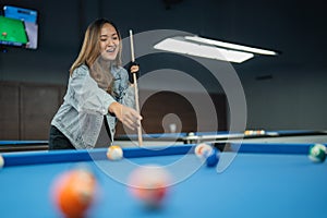 female billiard player pointing on the billiard balls while playing billiard