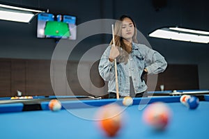 female billiard player standing with sullen face and put her hand on her waist