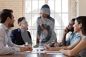 Female black executive talking to diverse employees at office briefing photo