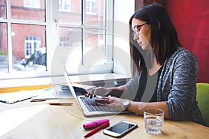 Female blogger keyboarding on netbook gadget