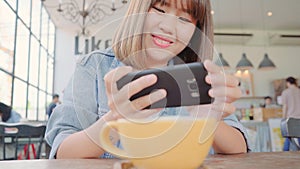 Female blogger photographing green tea cup in cafe with her phone. A young woman taking photo of coffee tea on smartphone,