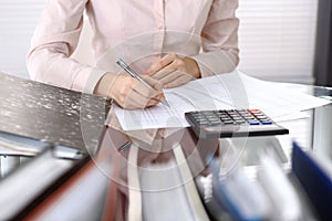 Female bookkeeper or financial inspector making report, calculating or checking balance. Internal Revenue Servic