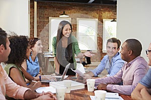 Female Boss Addressing Office Workers At Meeting photo