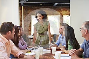 Female Boss Addressing Office Workers At Meeting photo