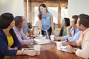 Female Boss Addressing Office Workers At Meeting