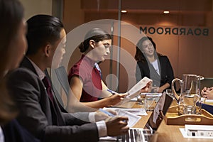 Female boss chairing business meeting in boardroom, close up