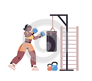 Female boxer doing exercises with punching bag training healthy lifestyle boxing concept