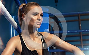 Female boxer posing inside a boxing ring.