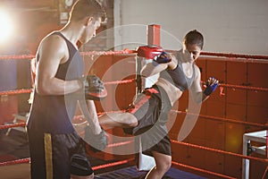 Female boxer practicing kickboxing with trainer her trainer