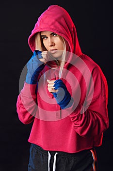 Female boxer prepares to punch at a boxing studio. Woman boxer in motion