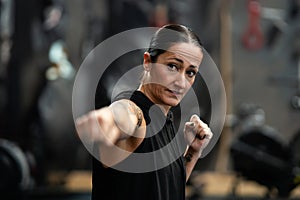 Female boxer throwing a jab while shadowboxing in the gym photo