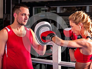 Female boxer throwing right cross at mitts