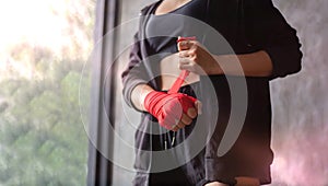A female boxer wrapped a boxing cloth on both hands