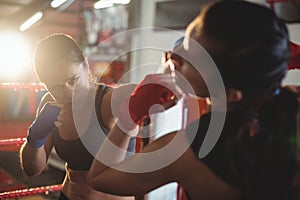 Female boxers fighting in boxing ring