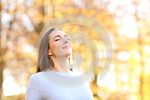 Female breathing fresh air in autumn in a forest