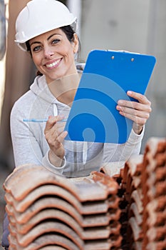 female builder in hardhat with clipboard