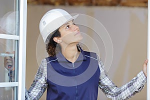 Female builder inspecting pvc windows