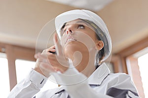 female builder pointing indoors