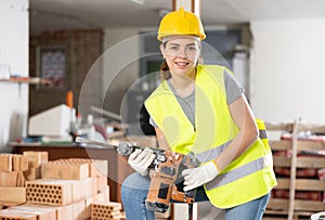 Female builder posing on indoor construction site