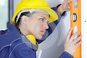 female builder using spirit level
